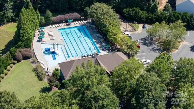 an aerial view of a house with a yard and trees all around