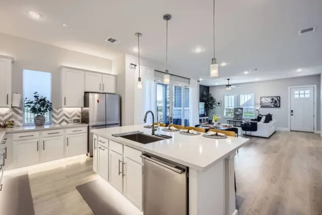 a kitchen with refrigerator a sink and chairs