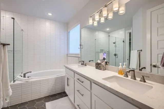 a bathroom with a bathtub a double vanity sink and a mirror