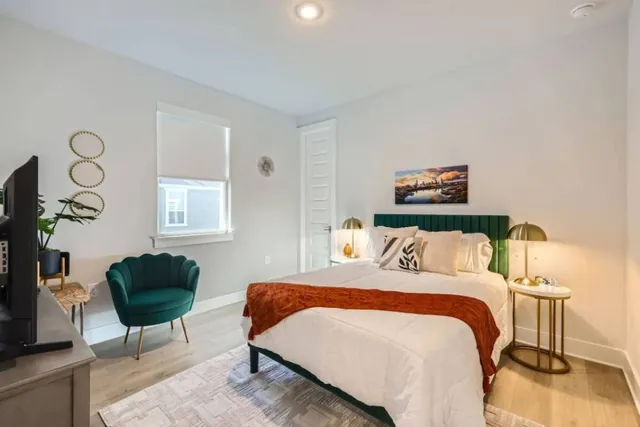 a bedroom with a bed a chair and a potted plant