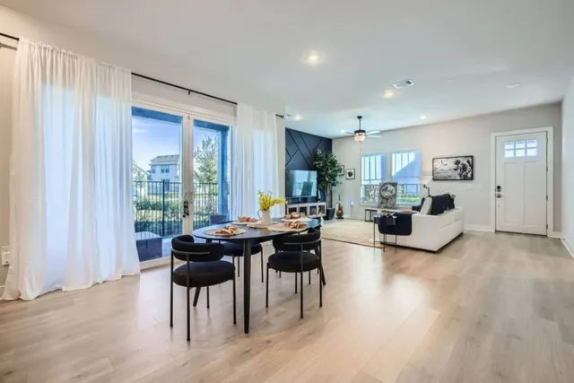 a living room with furniture a wooden floor and a large window