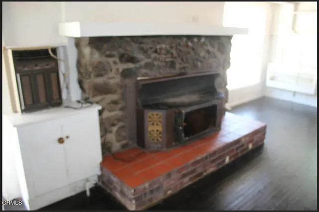 a room with wooden floor and a fireplace