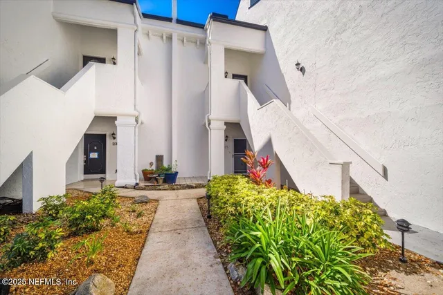 a view of a pathway of house with flower plants