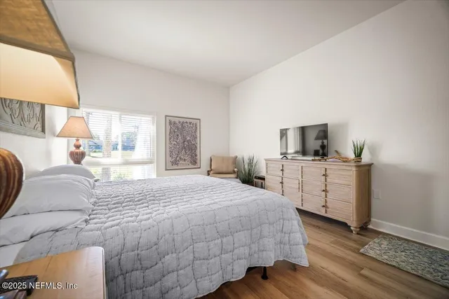 a bedroom with a bed and a lamp on dresser