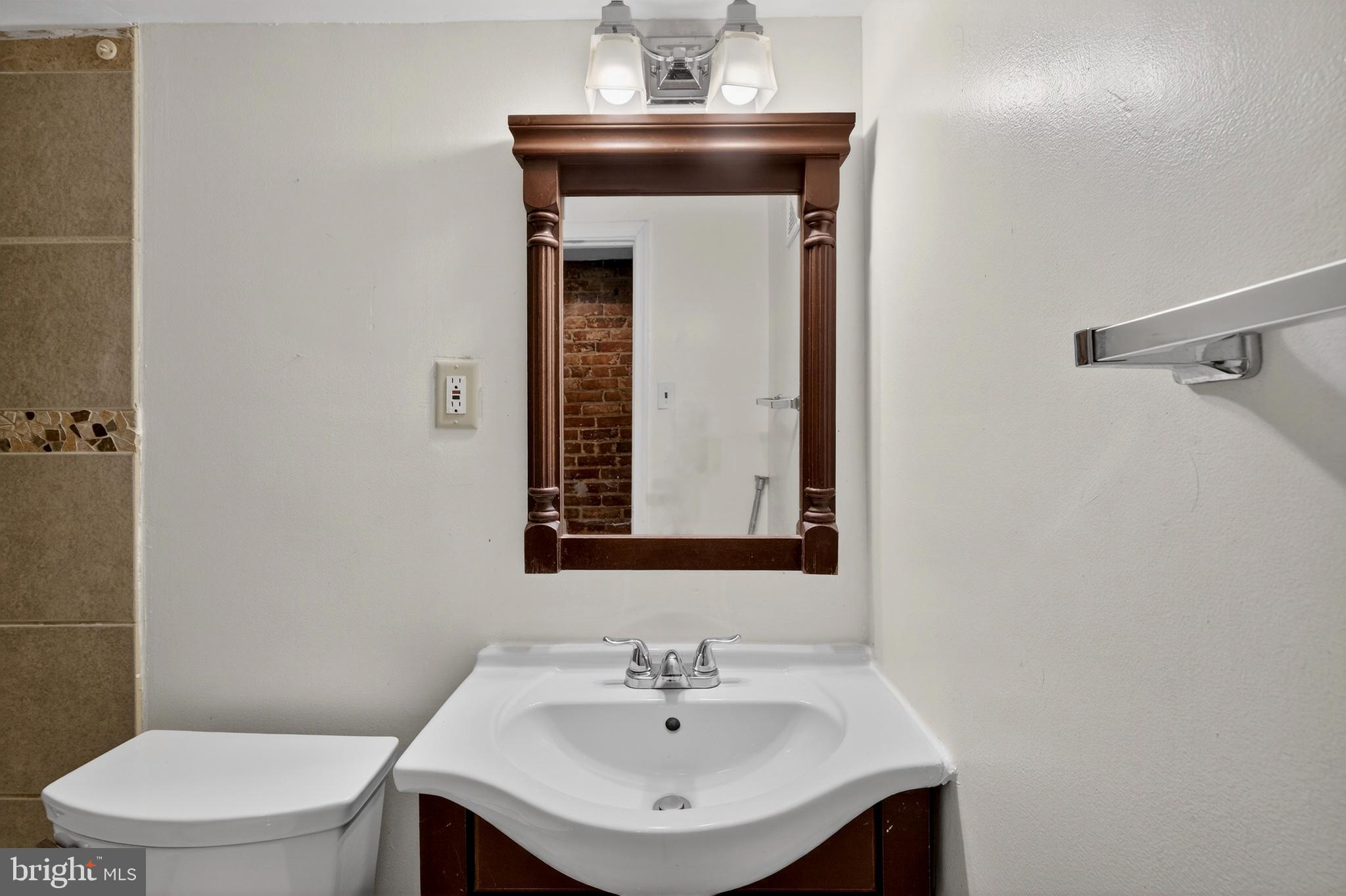 1351 Monroe Street Northwest Washington, DC 20010 - Photo 12 of 23 a bathroom with a sink a toilet and mirror