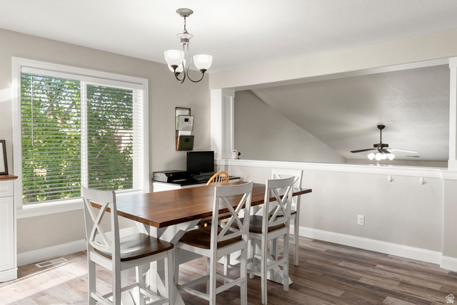 2485 South 1100th Street West Logan, UT 84321 - Photo 16 of 53 Dining area with wood-finish flooring, a large window with blinds, and a contemporary chandelier