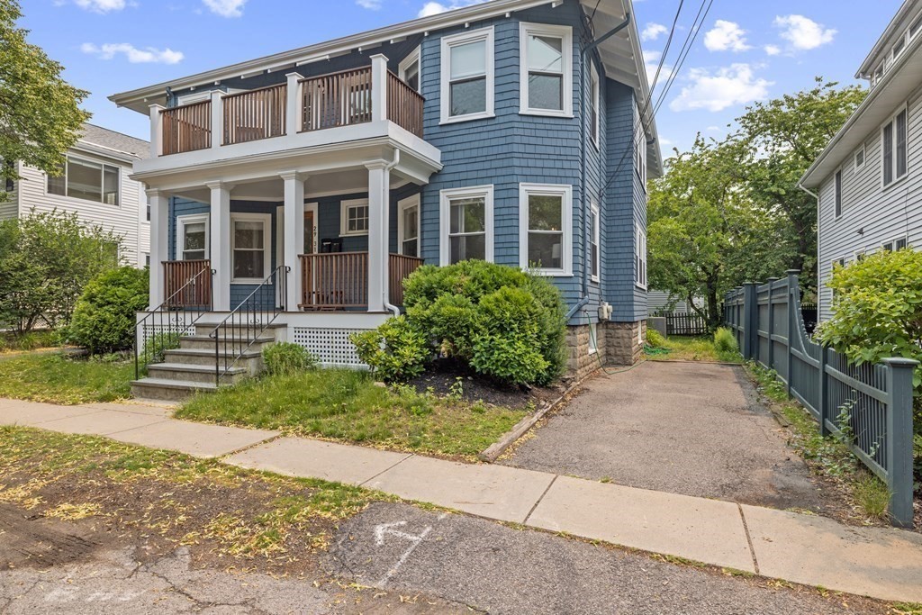 29 Worcester Street, Unit 1 Belmont, MA 02478 - Photo 23 of 27 a view of a brick house with many windows plants and large tree