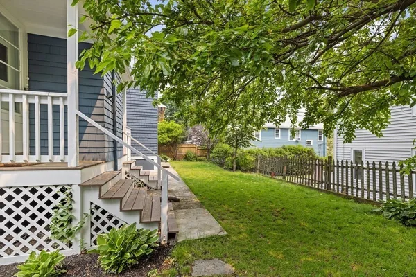 a view of a yard with plants and wooden fence