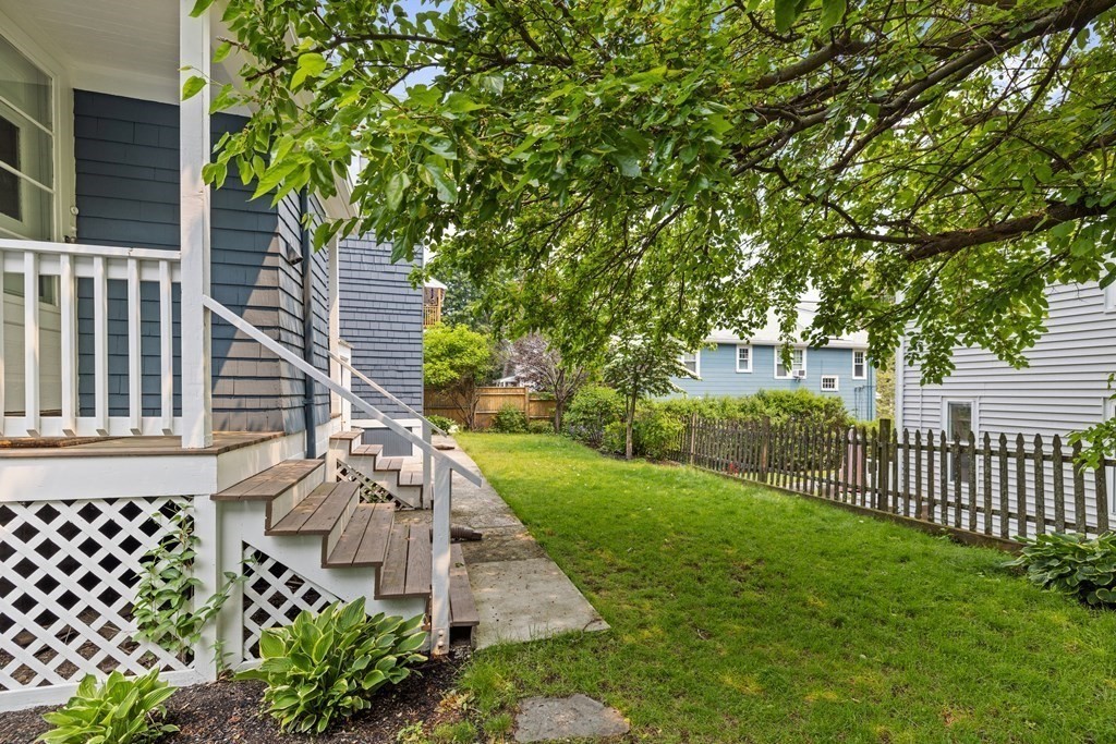 29 Worcester Street, Unit 1 Belmont, MA 02478 - Photo 24 of 27 a view of a yard with plants and wooden fence