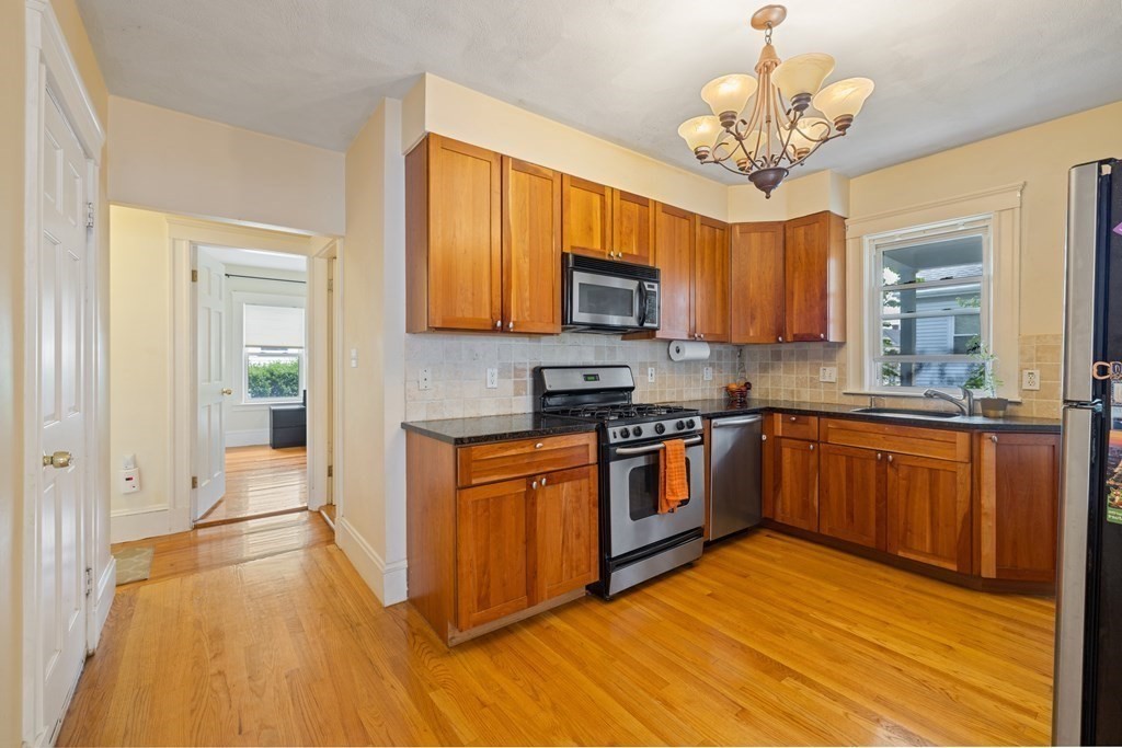 29 Worcester Street, Unit 1 Belmont, MA 02478 - Photo 3 of 27 a large kitchen with stainless steel appliances granite countertop a stove a sink dishwasher a microwave oven with cabinets and wooden floor