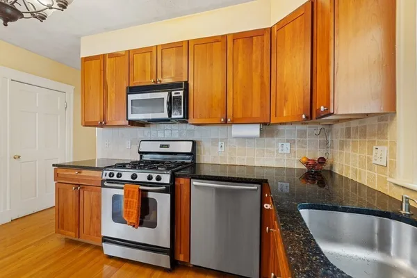 a kitchen with wooden cabinets a sink and a stove top oven