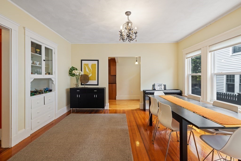 29 Worcester Street, Unit 1 Belmont, MA 02478 - Photo 10 of 27 a large living room with a dining table wooden floor and a chandelier