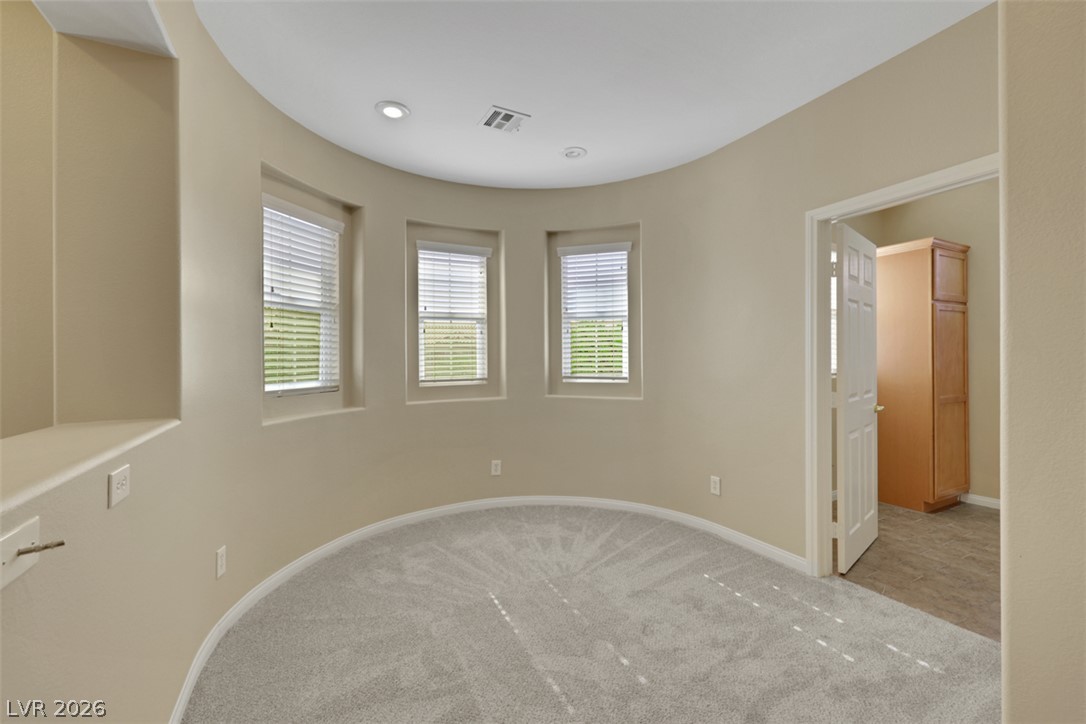 10328 Hawk Ravine Street Las Vegas, NV 89178 - Photo 24 of 55 A curved wall with multiple windows adds architectural interest to this well-lit room.