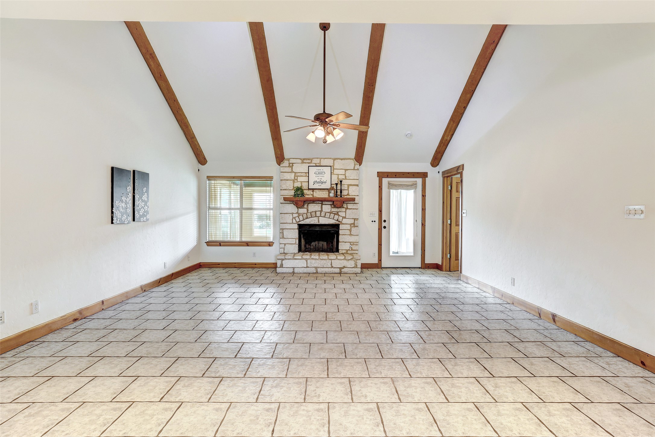 125 Kyle Lane Georgetown, TX 78633 - Photo 14 of 34 Unfurnished living room with a stone fireplace, lofted ceiling, a ceiling fan, and light tile patterned flooring
