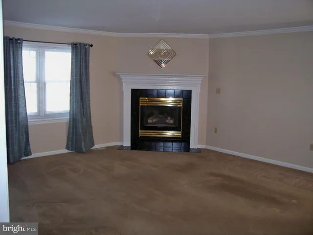 a view of an empty room with a fireplace