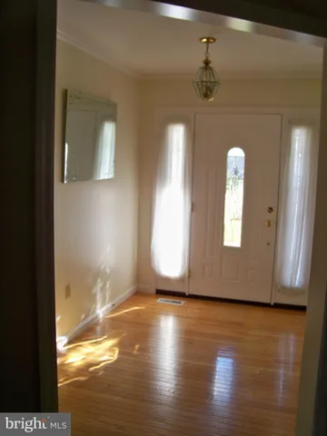 a view of a room with wooden floor and a window