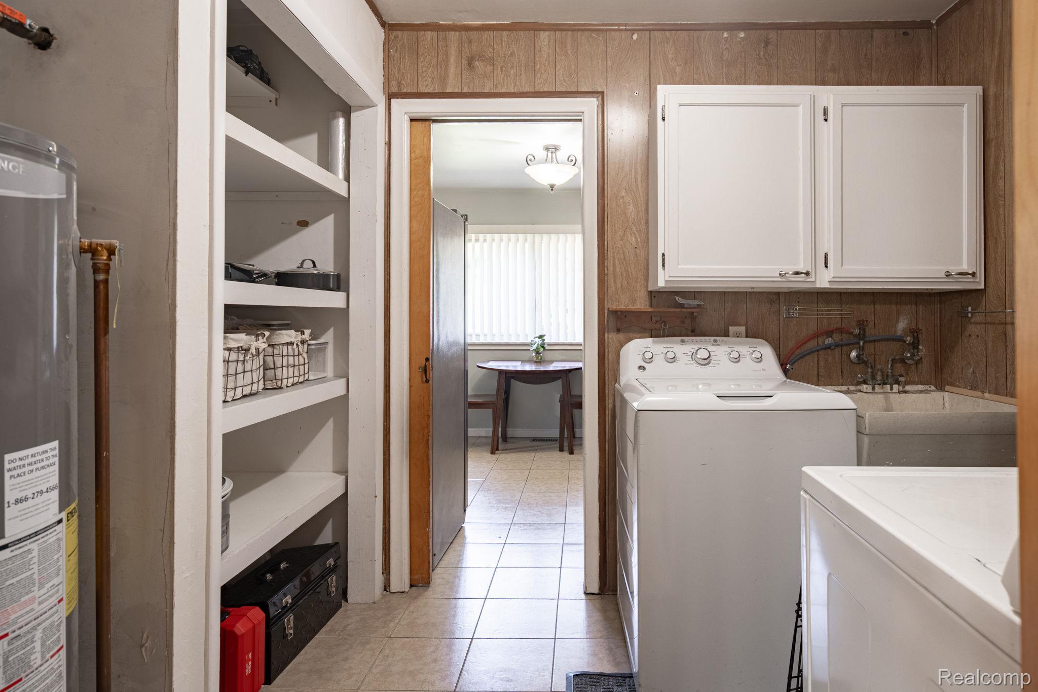 9041 Rackham Street Taylor, MI 48180 - Photo 32 of 34 Laundry area featuring a utility sink, wall-mounted cabinetry, and built-in shelving