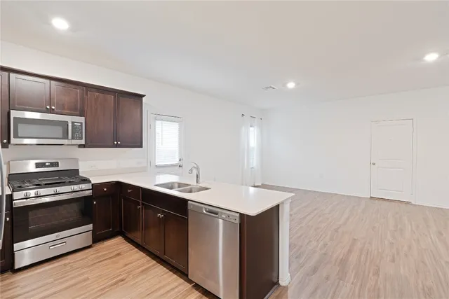 a kitchen with sink a microwave and cabinets