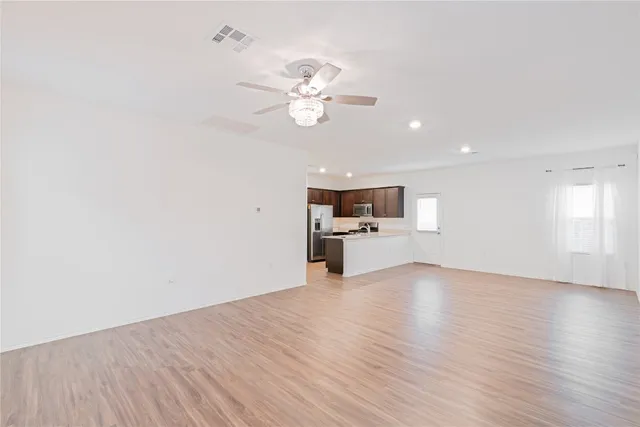 a view of a kitchen with wooden floor and a ceiling fan