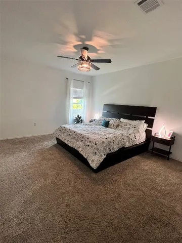 a bedroom with a bed chandelier and a window