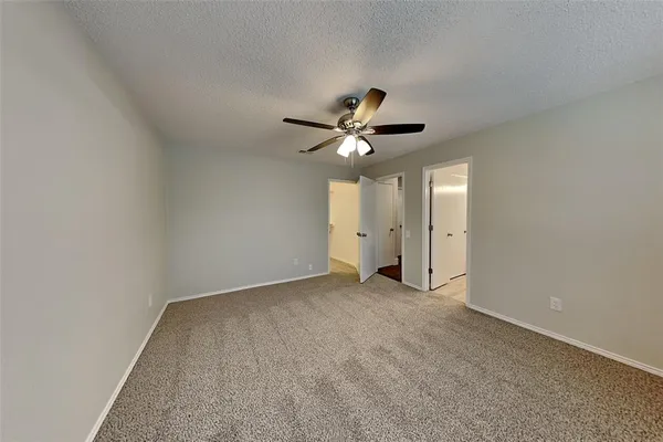 an empty room with a ceiling fan and a window
