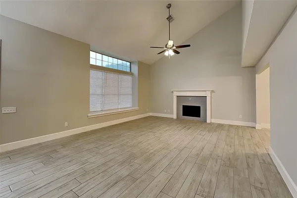 a view of empty room with wooden floor and fireplace