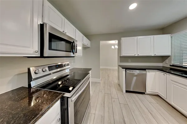 a kitchen with appliances a sink and cabinets