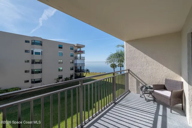 a balcony view with two chairs and a table