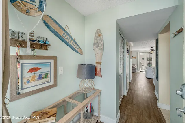 a view of hallway with furniture and wooden floor