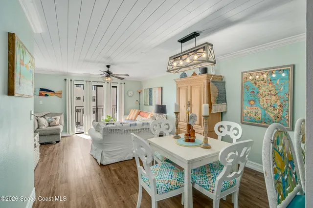 a view of a dining room with furniture a chandelier and wooden floor