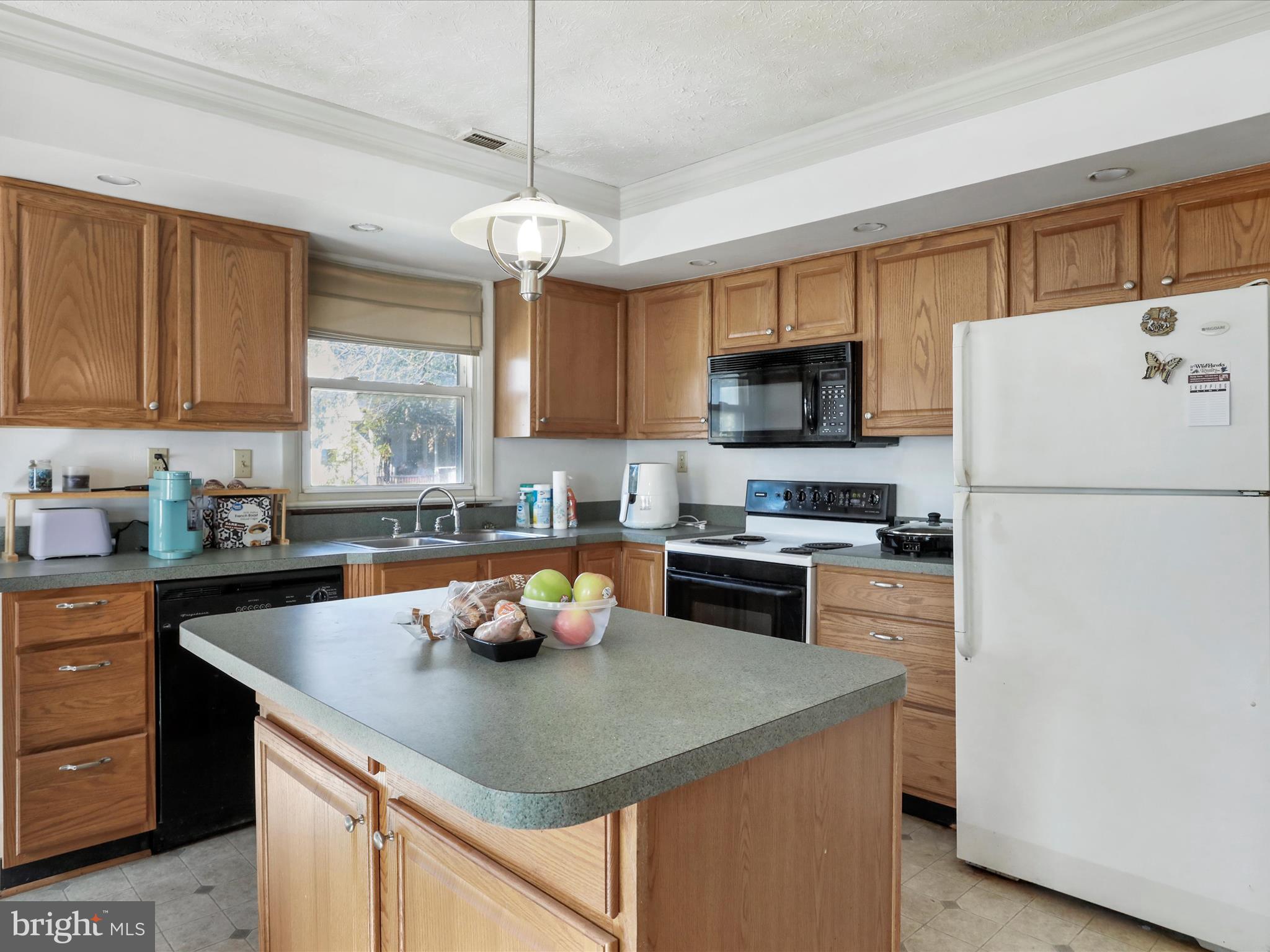 239 Chestnut Street Winchester, VA 22601 - Photo 10 of 35 a kitchen with a refrigerator a stove a microwave and wooden cabinets