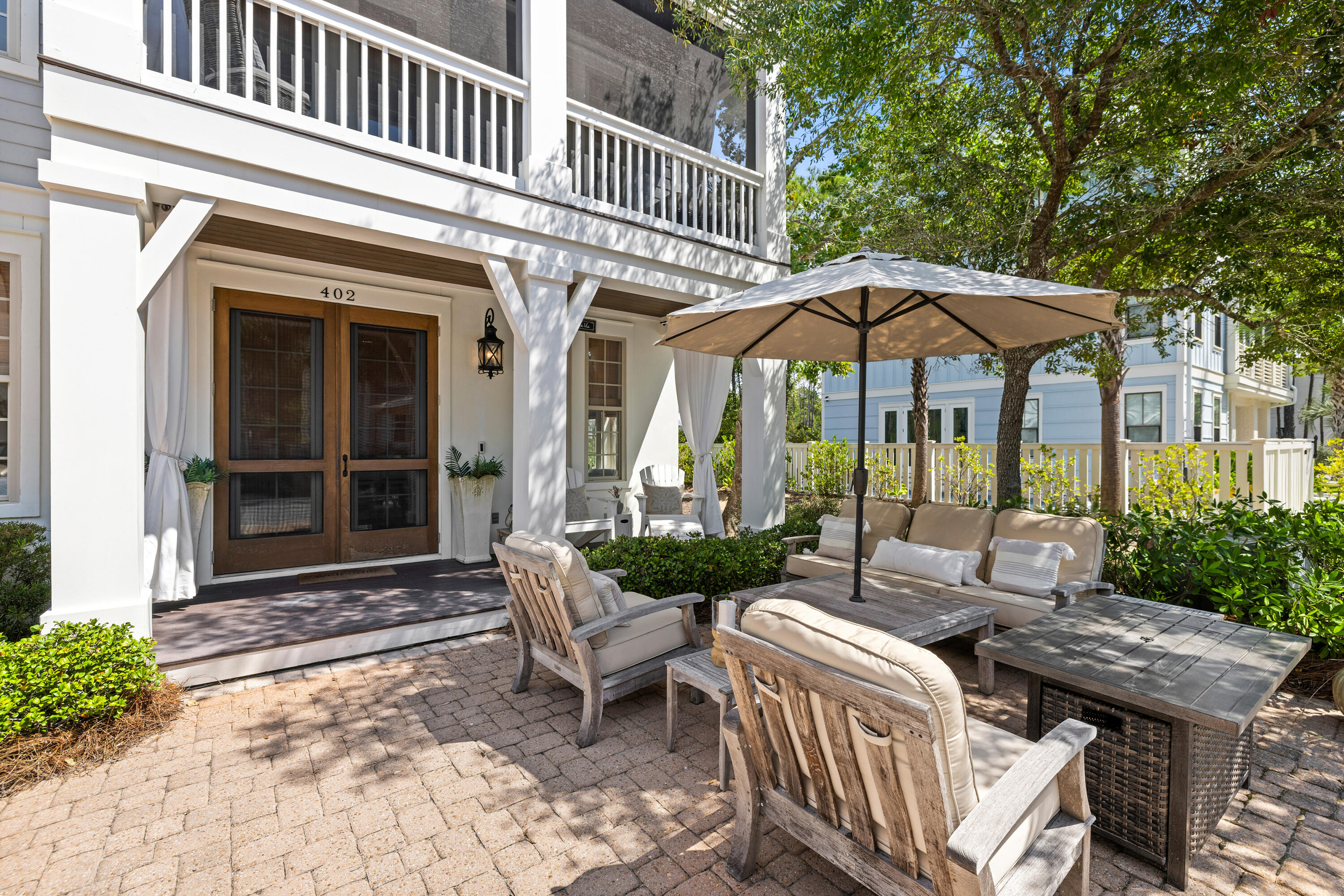 402 Redbud Lane Inlet Beach, FL 32461 - Photo 34 of 44 a view of a patio with couches table and chairs under an umbrella with a barbeque