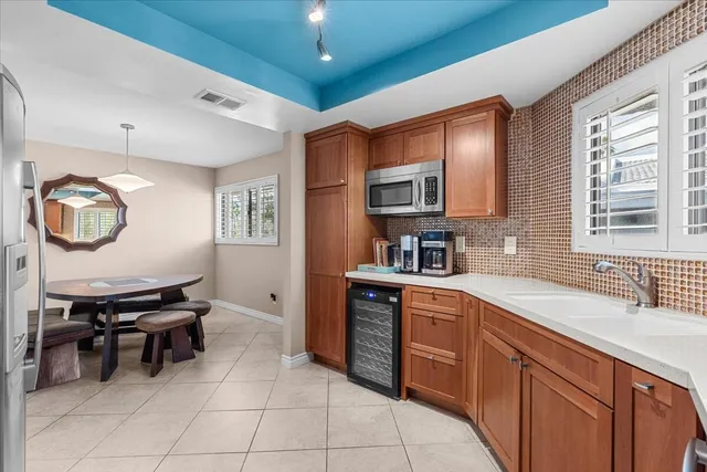 a kitchen with stainless steel appliances a sink a stove a refrigerator cabinets and dining table