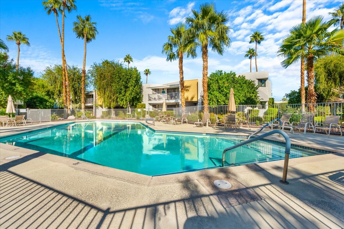 3155 Ramon Road, Unit 312 Palm Springs, CA 92264 - Photo 27 of 34 a view of a swimming pool with a garden and trees