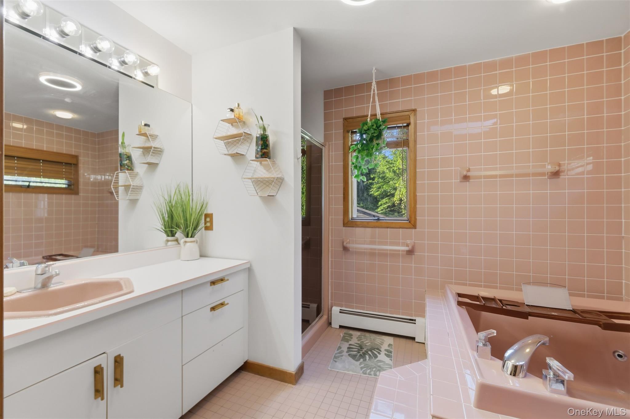 985 Craigville Road Chester, NY 10918 - Photo 23 of 36 Bathroom featuring a pink tiled shower surround, a built-in jetted tub with integrated shelving, and a vanity with a drop-in sink
