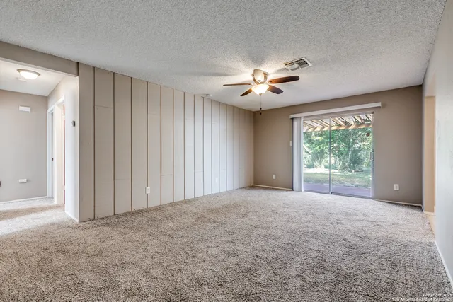 a view of a room with a large window and a ceiling fan