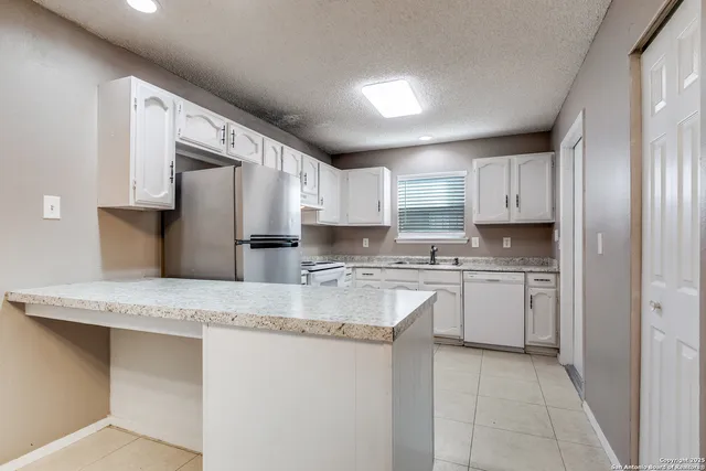 a kitchen with stainless steel appliances granite countertop a sink a stove and a refrigerator