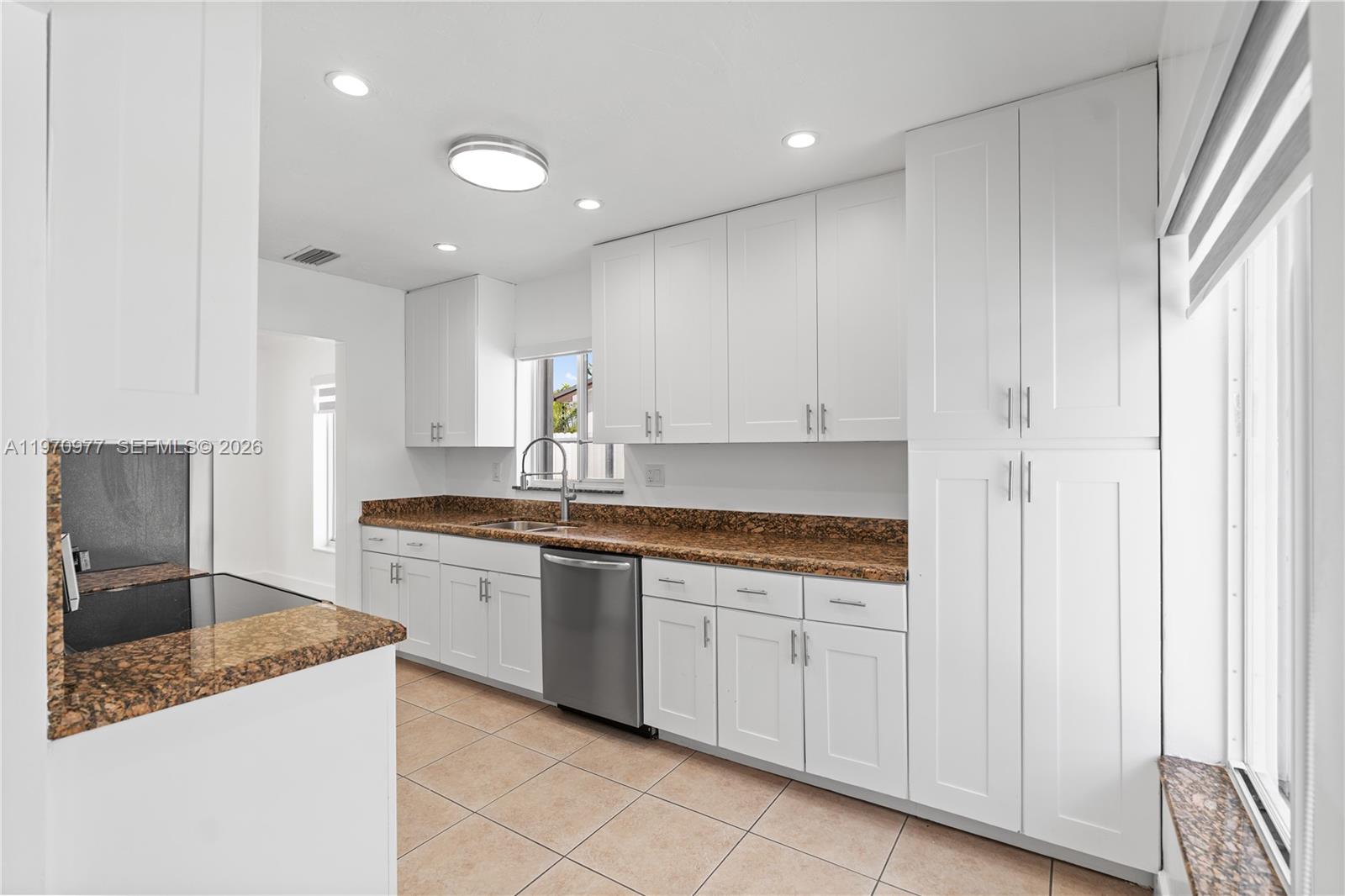 5103 Southwest 128th Place Miami, FL 33175 - Photo 12 of 38 a kitchen with stainless steel appliances granite countertop a sink and cabinets