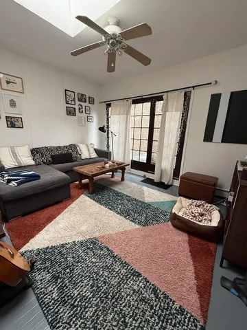 a living room with furniture a rug and a window