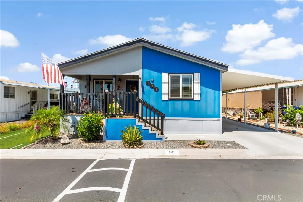 a front view of a house with a yard and potted plants