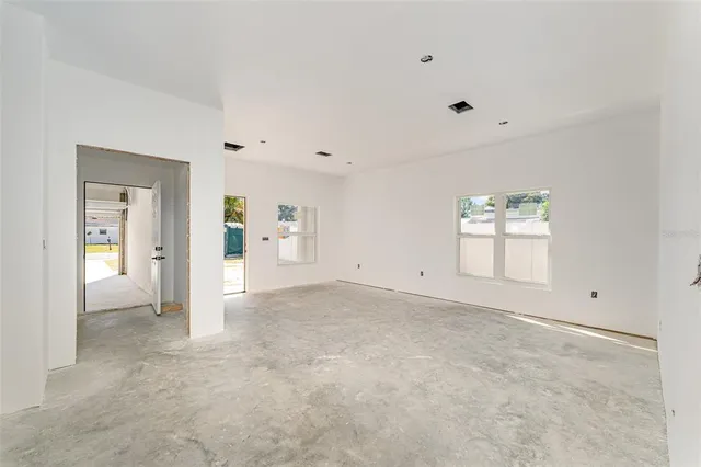 an empty room with windows and bathroom