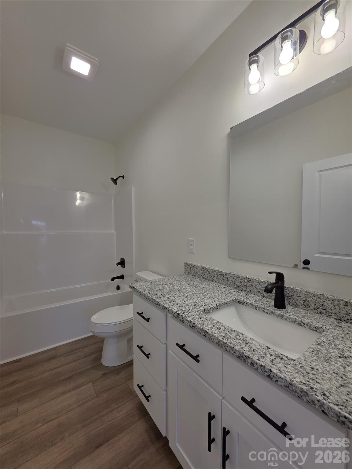 126 Heath Street Albemarle, NC 28001 - Photo 7 of 16 a bathroom with a granite countertop sink a toilet and bathtub