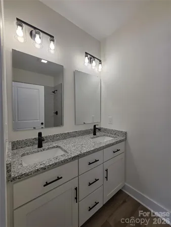 a bathroom with a granite countertop sink and a mirror