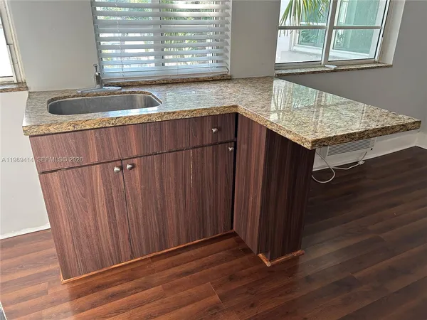 a bathroom with a granite countertop sink and a window