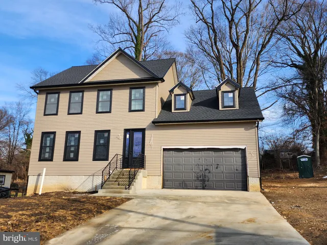 a front view of a house with yard and parking
