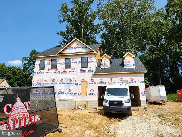 a front view of a house with cars parked