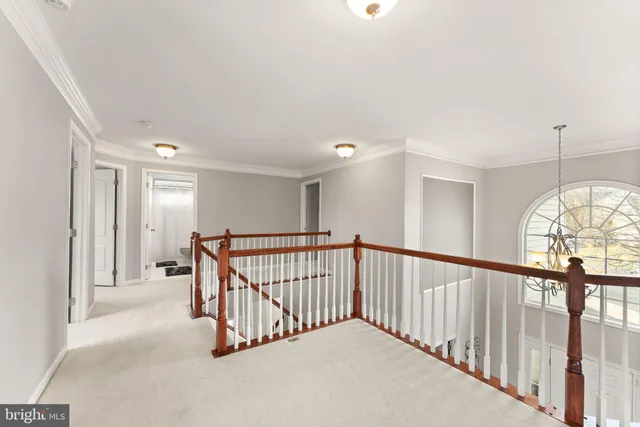 a view of an empty room with wooden floor and windows