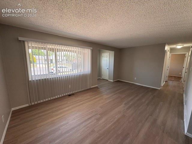 1922 Monterey Road Colorado Springs, CO 80910 - Photo 5 of 21 an empty room with wooden floor and windows