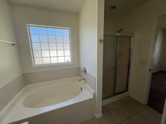 a white bath tub sitting in a bathroom next to a window