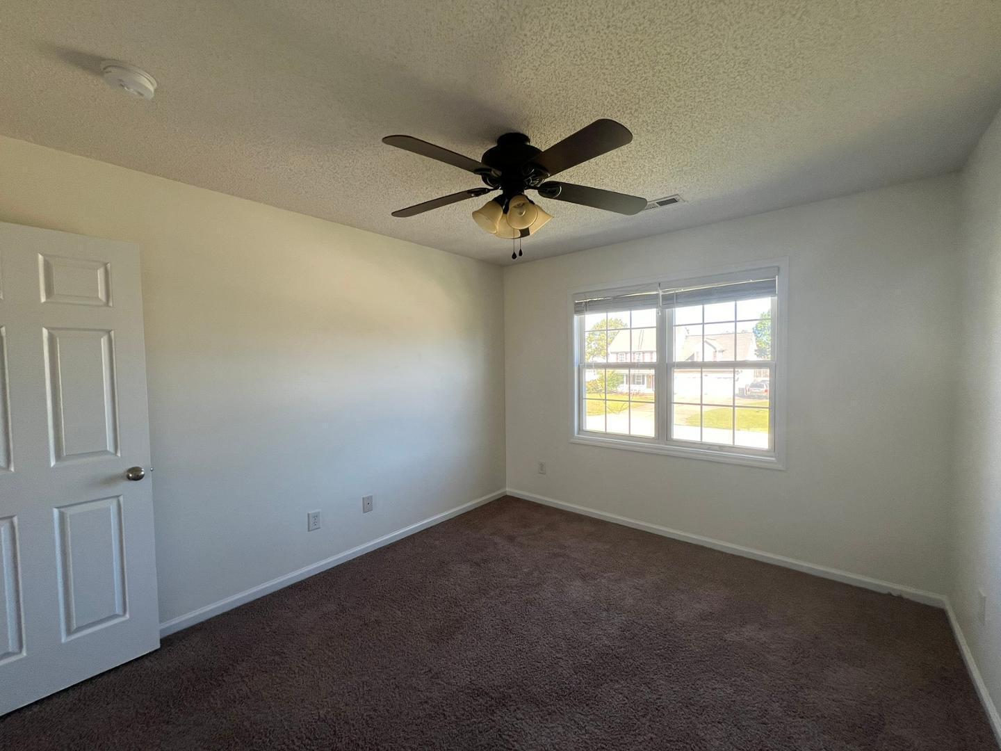 100 Dover Court East Sanford, NC 27332 - Photo 16 of 20 an empty room with a window and a fan